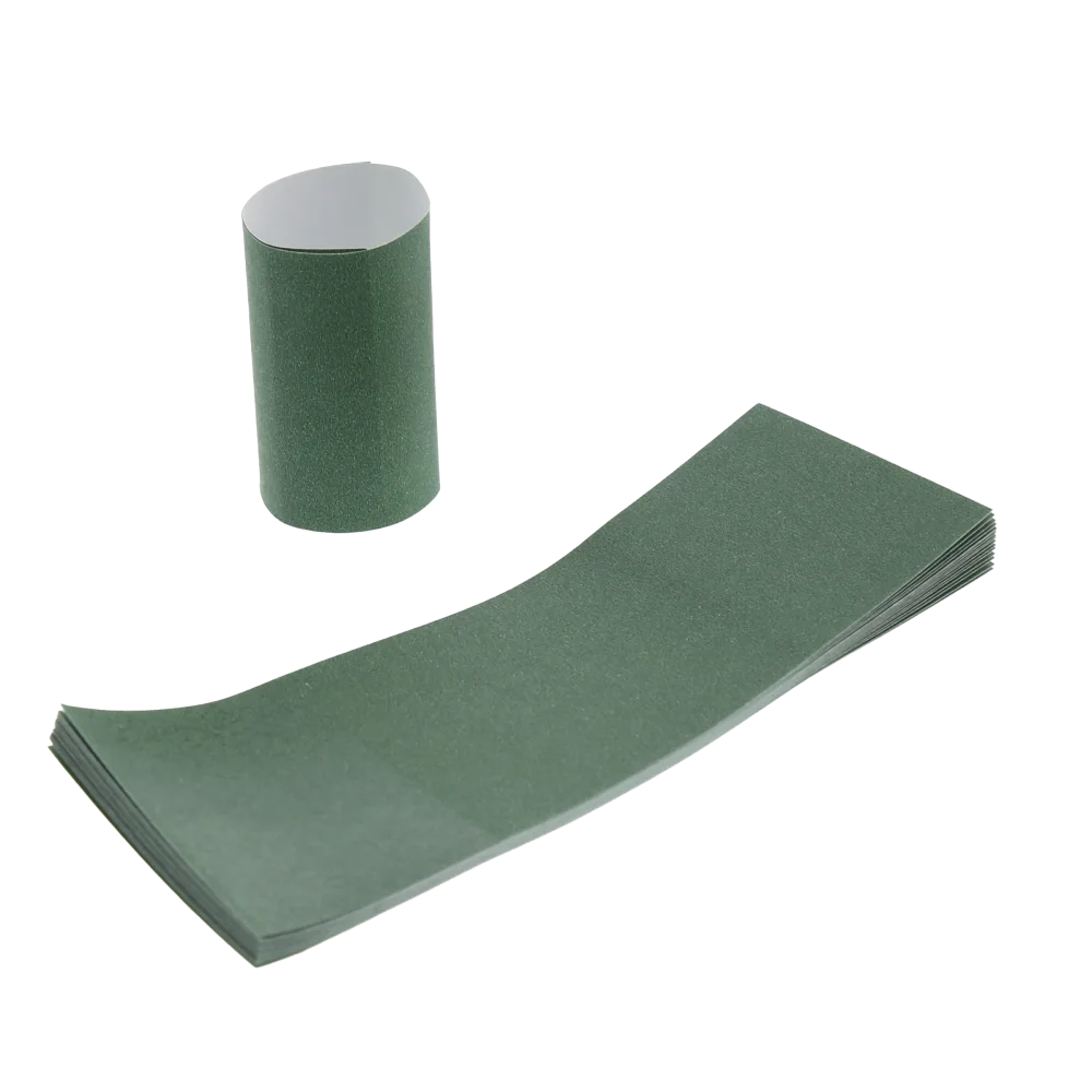 Stack of dark green self-sealing napkin bands with one formed into a rolled ring and one partially lifted to show the adhesive strip, displayed on a white background.
