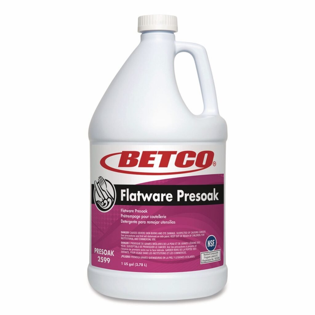 One-gallon bottle of Betco Flatware Presoak with a white cap and handle. The label features the Betco logo in red, product name in bold white text on a black background, and usage information in English, French, and Spanish on a purple background.