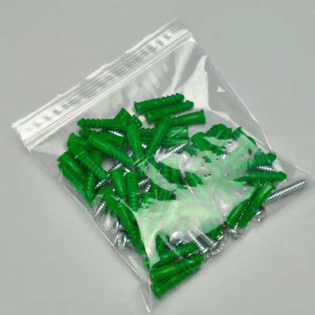 A resealable plastic bag filled with green wall anchors and silver screws.